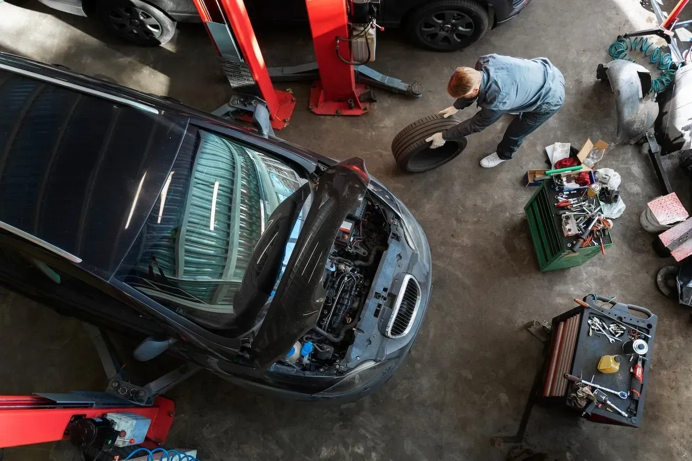A man is working on a car in a garage.