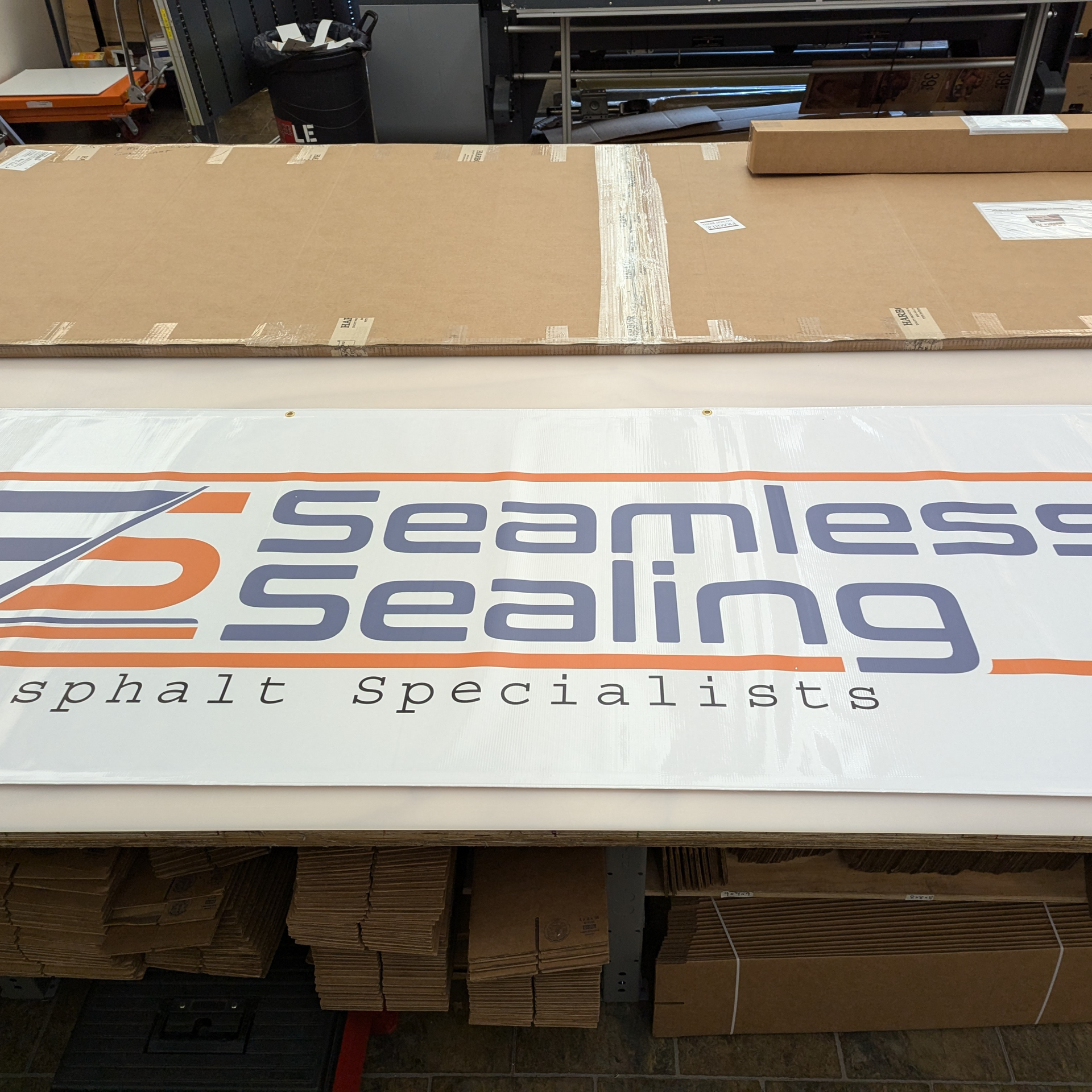 A sign that says seamless sealing asphalt specialists by Press Enterprise Commercial Printing