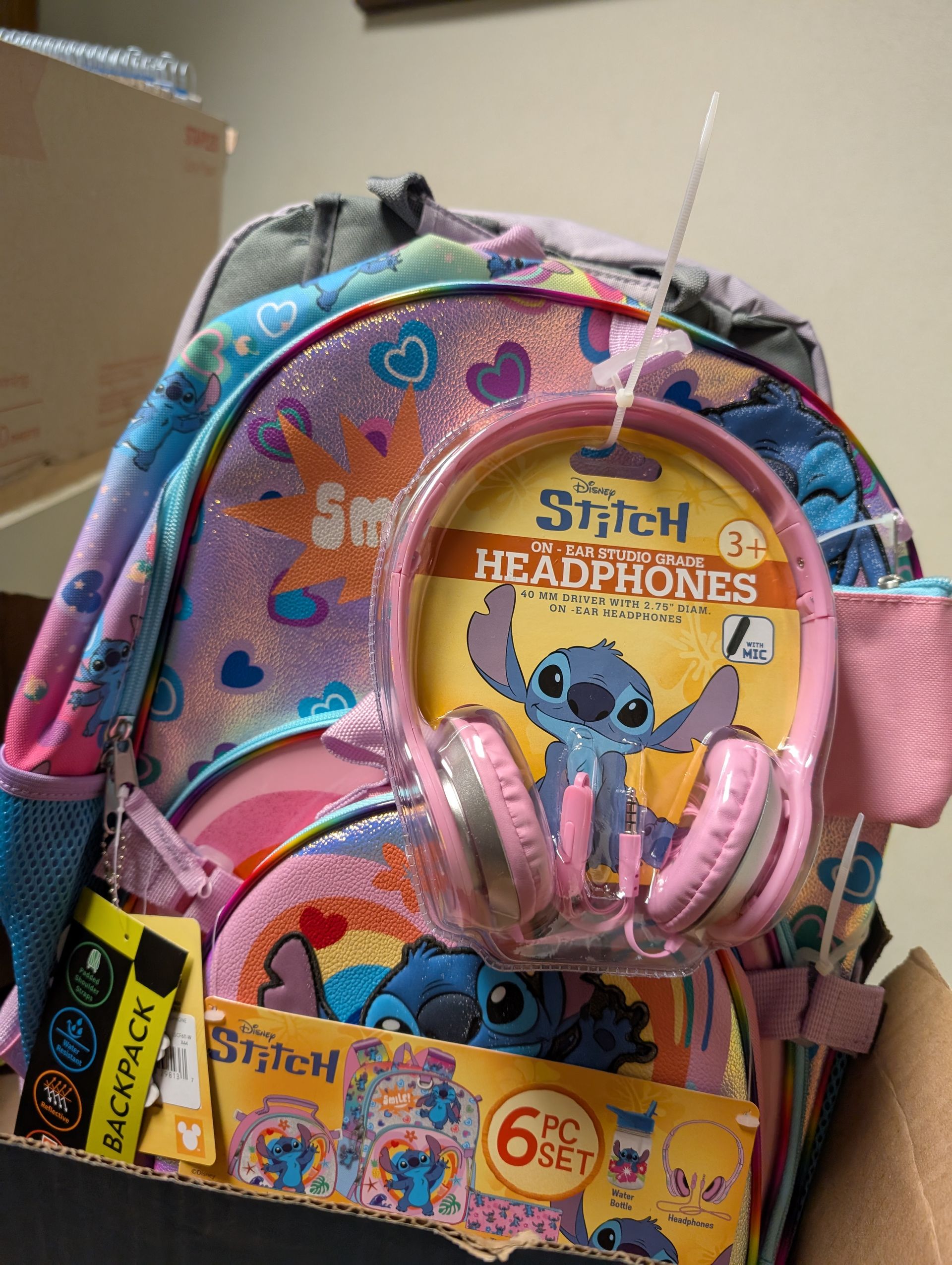 Stitch-themed backpack set with headphones and a 6-piece stationery set, featuring a blue and pink color scheme.