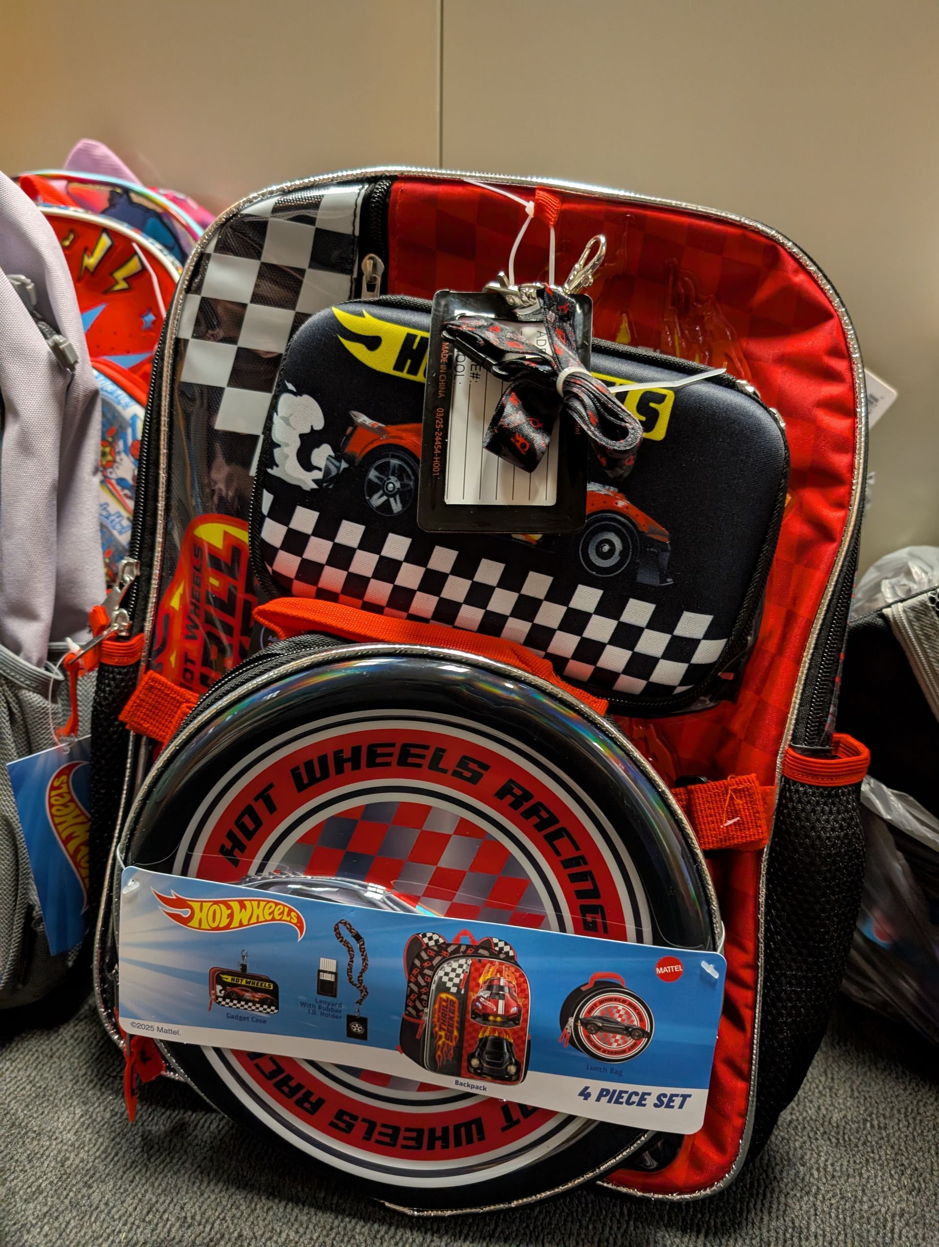 Hot Wheels backpack with checkerboard, tire design, and attached accessories.