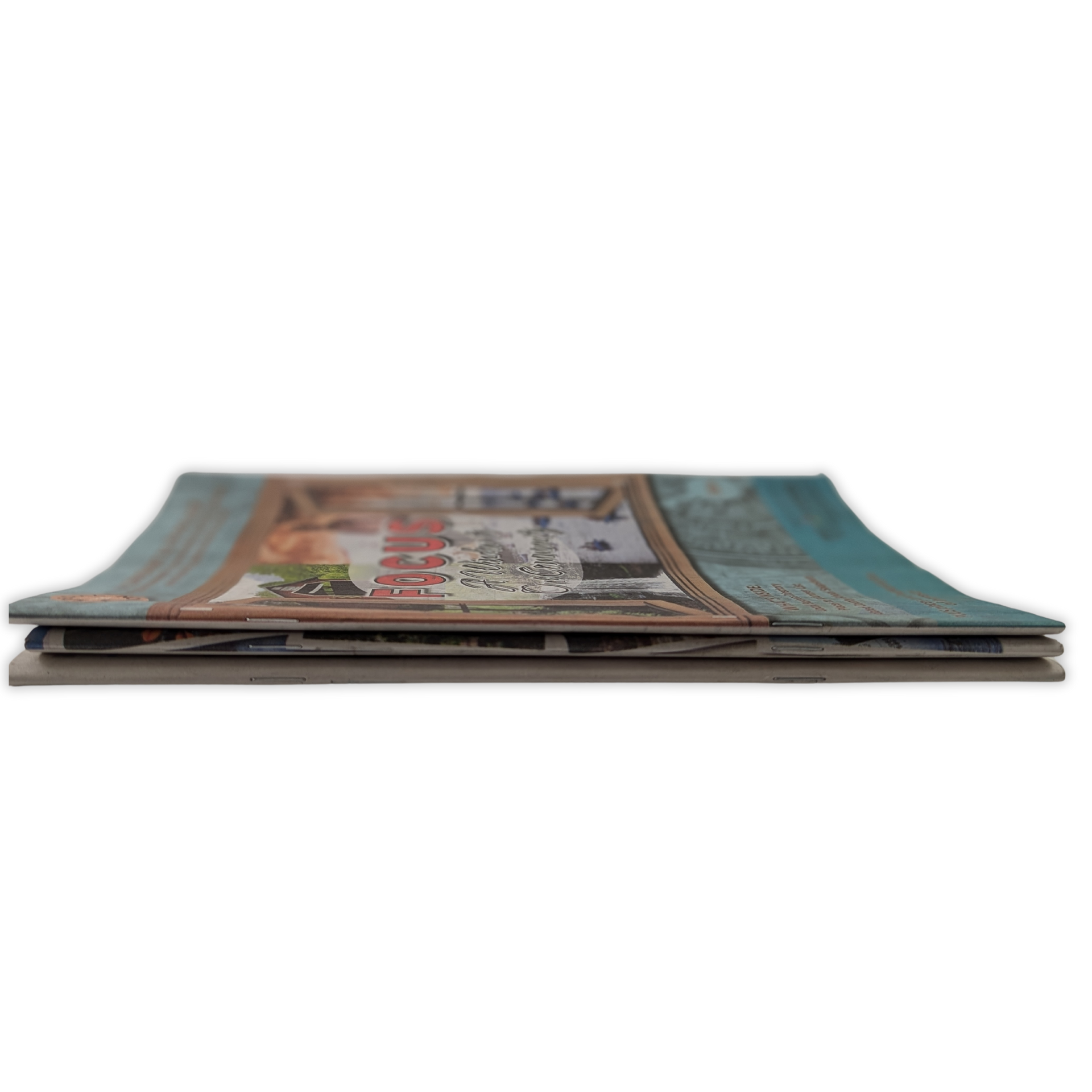 A stack of magazines sitting on top of each other on a table by Press Enterprise Commercial Printing