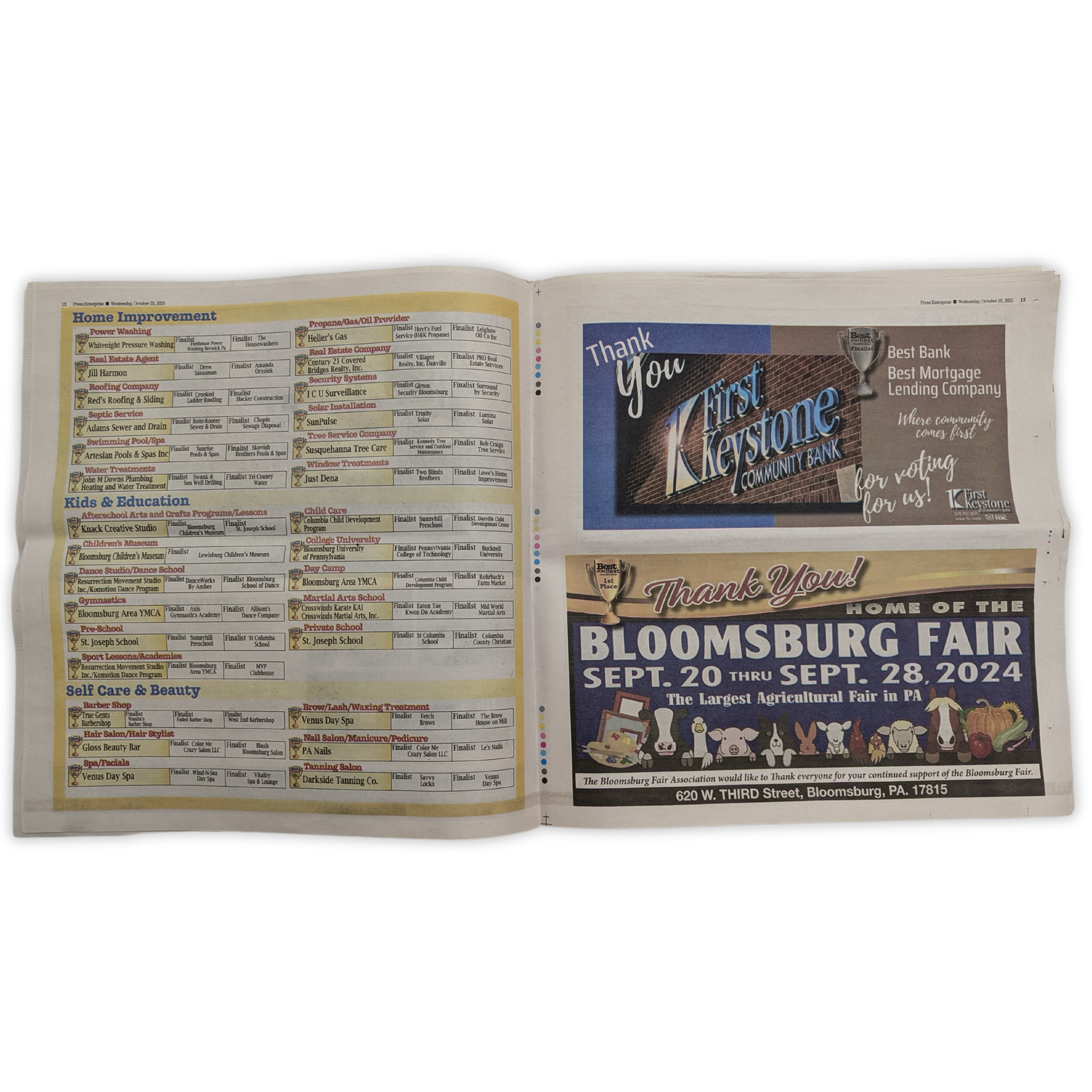 A newspaper is open to a page that says bloomsburg fair by Press Enterprise Commercial Printing