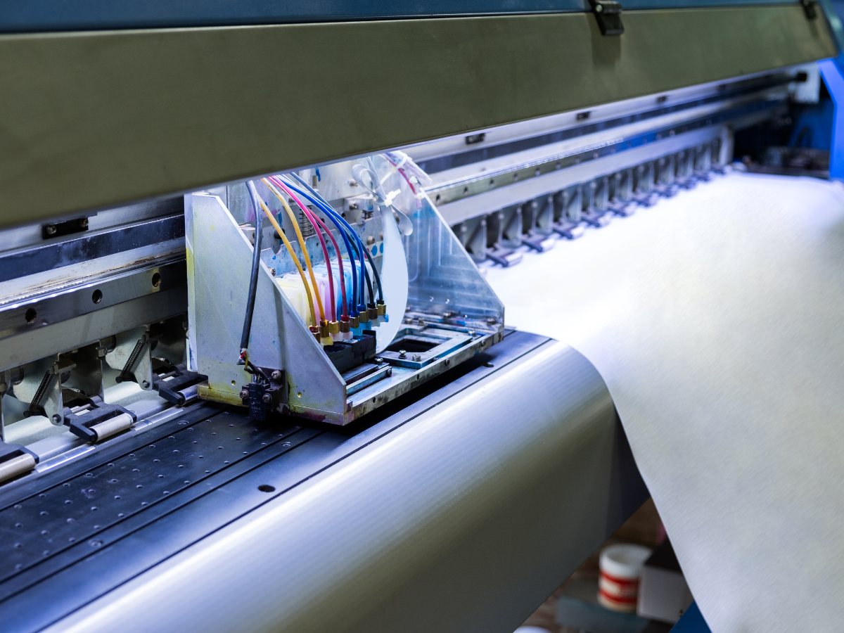 A large printer is printing a banner. A large printer is printing a banner.