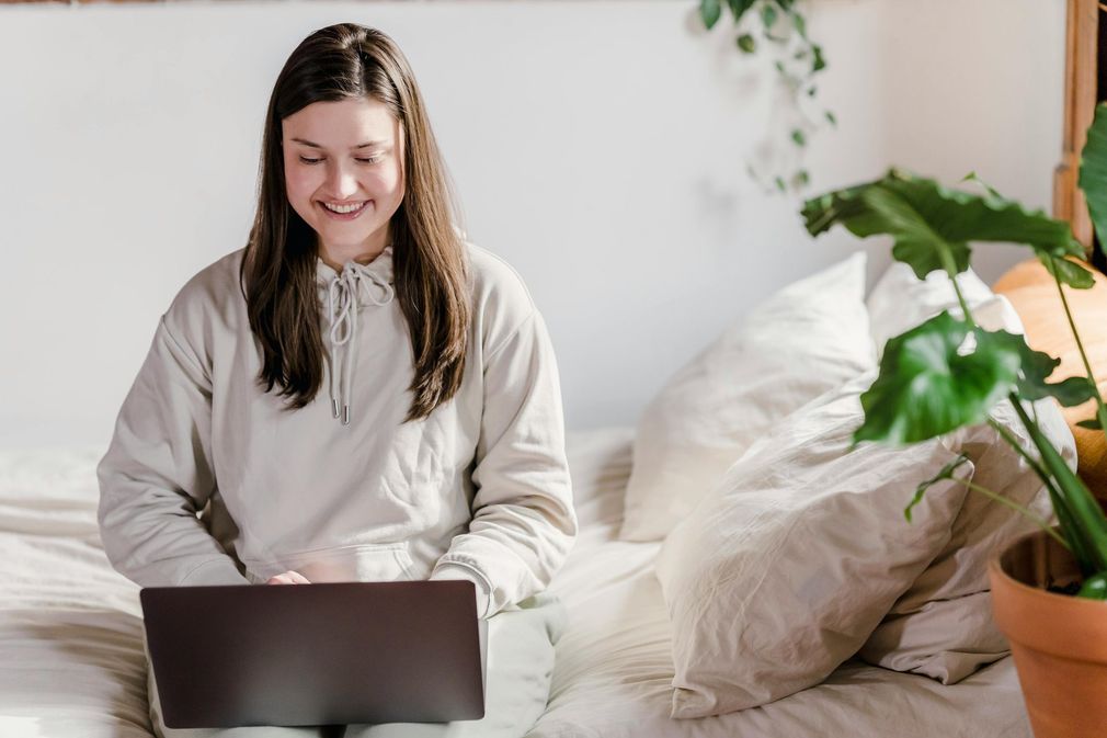 A woman is sitting on a couch while a woman writes on a clipboard.