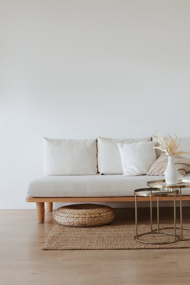 A living room with a couch , tables , and a rug.