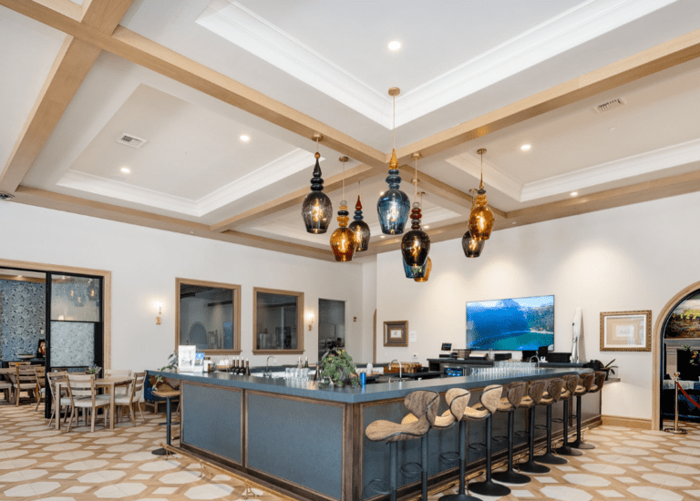 Bright tasting room with large blue bar, patterned floor, and hanging pendant lights