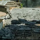 Close-up of 665 mesh reinforcement with concrete being poured over it in excavation for a driveway project in Kelson.