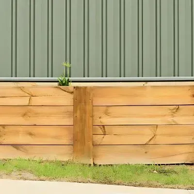 Timber retaining wall with aluminium fence constructed by builders in Gracefield.