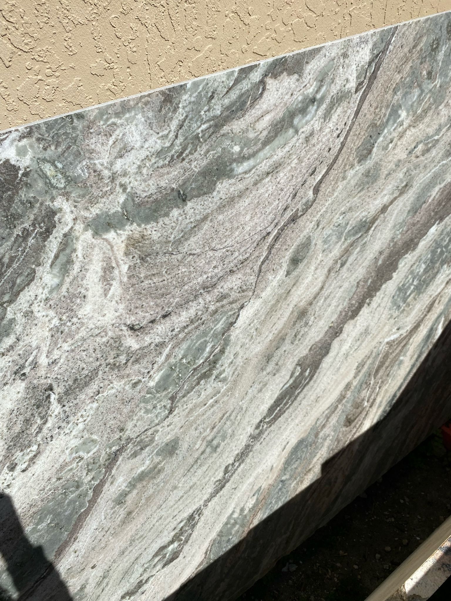 Countertop made of stone with swirling patterns of white, gray, and brown.