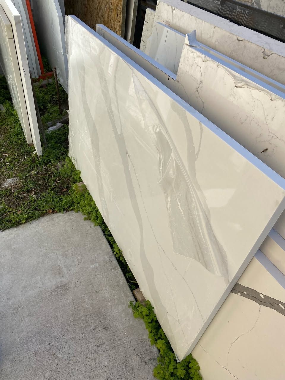 White countertop slabs stacked outdoors.