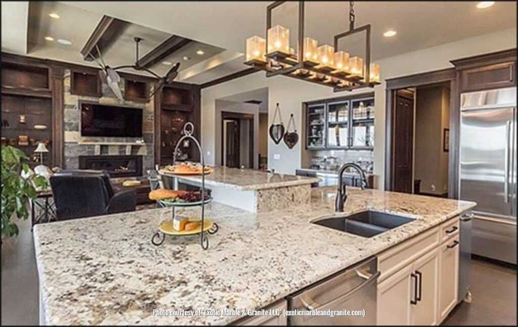 Modern kitchen with granite countertops, island with tiered tray, and linear light fixture.