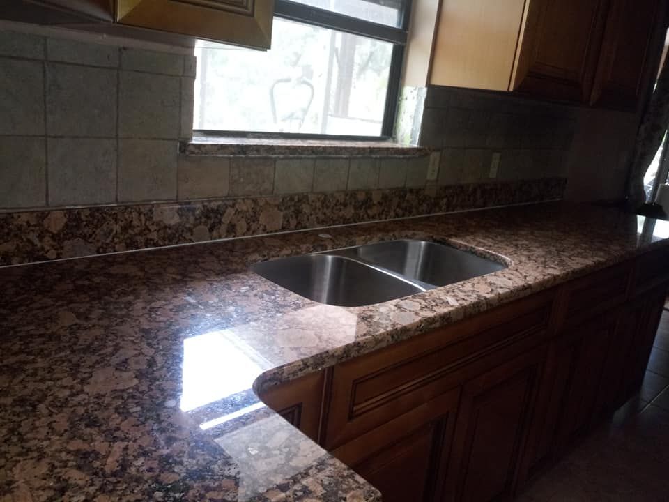 Kitchen with granite countertop, double sink, and wooden cabinets.