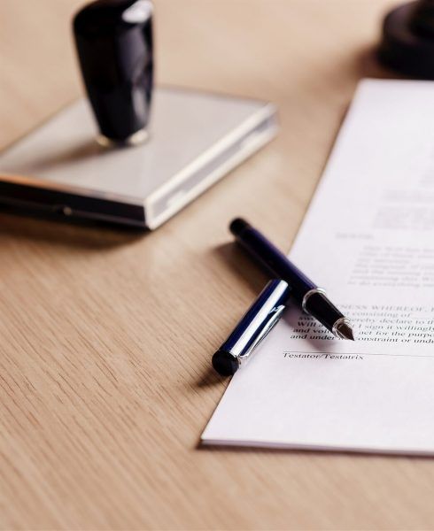 Wooden Desk With Contract, Pen, And Stamp — Finlayson & McKenzie Funeral Directors in Rockhampton City, QLD