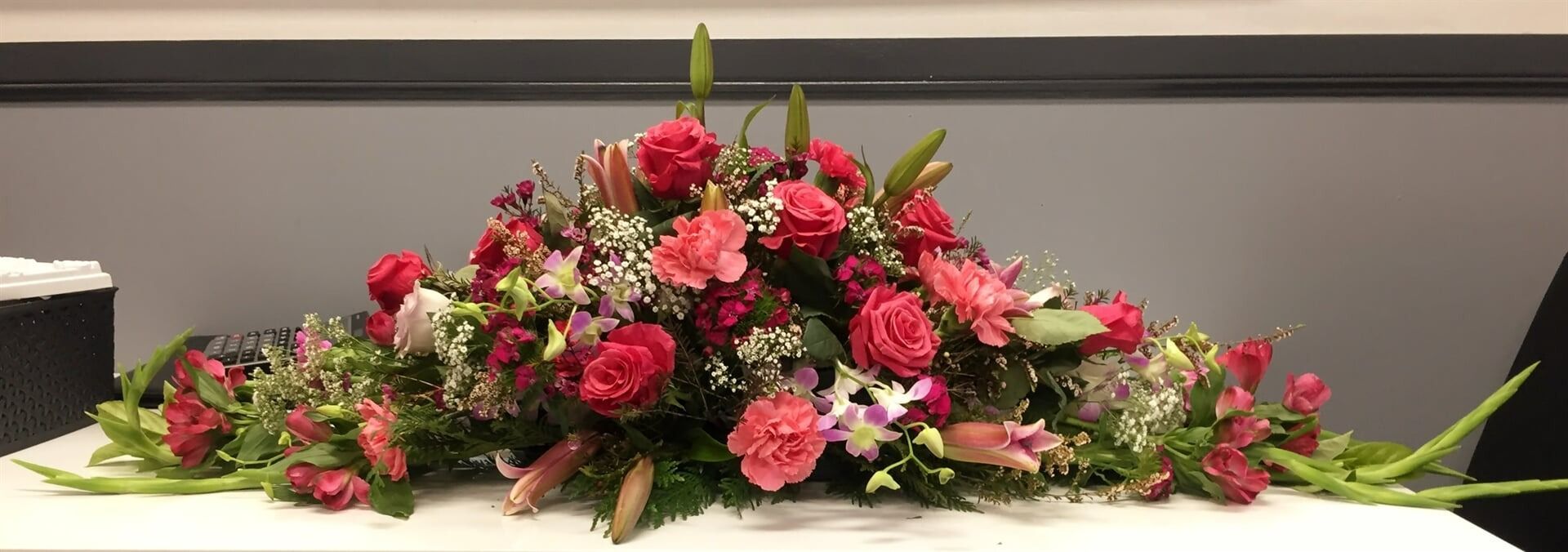 A Floral Arrangement With Red Roses and Other Flowers — Finlayson & McKenzie Funeral Directors in Rockhampton City, QLD