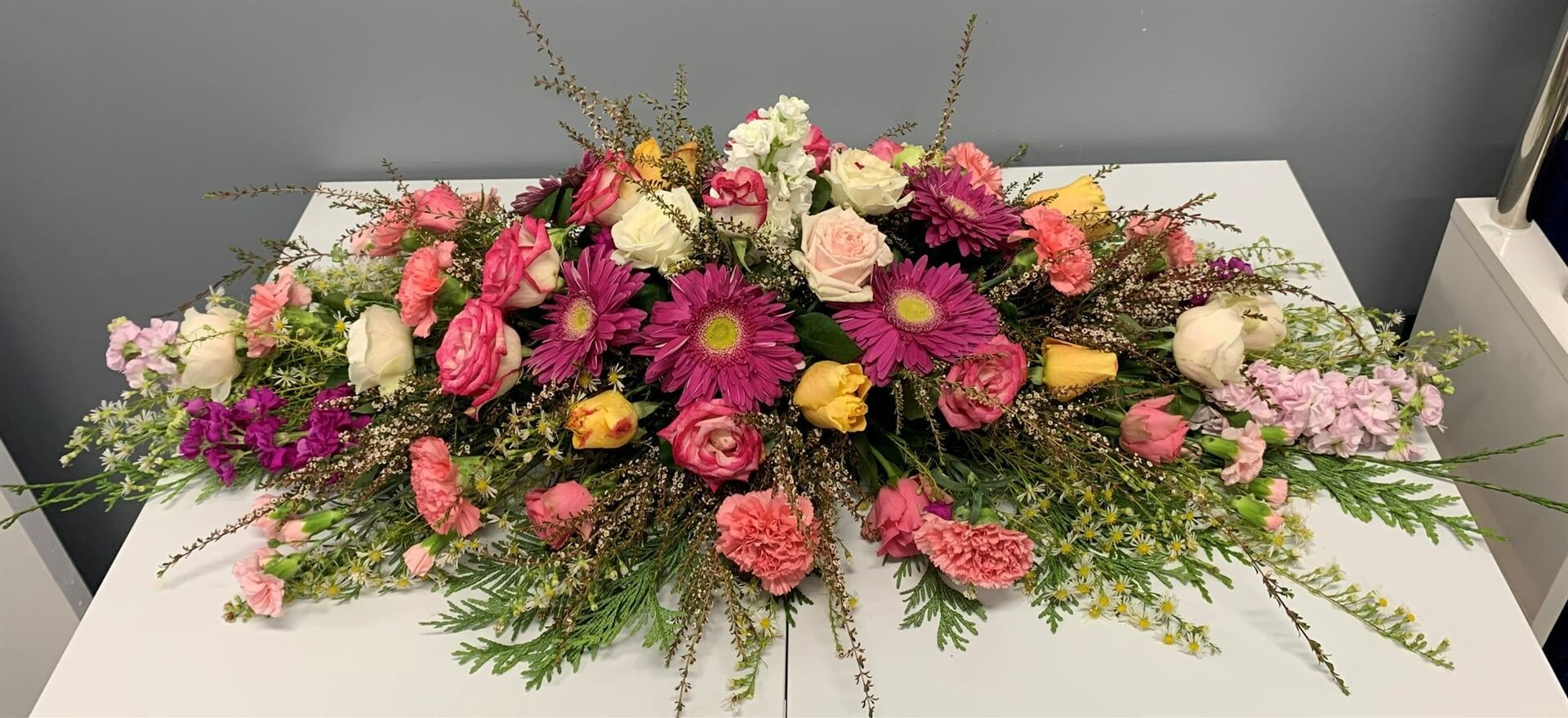 Floral Arrangement on a White Surface — Finlayson & McKenzie Funeral Directors in Rockhampton City, QLD