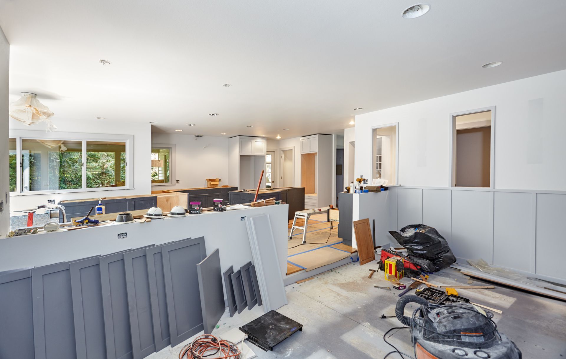 A large room under construction with a lot of tools on the floor.