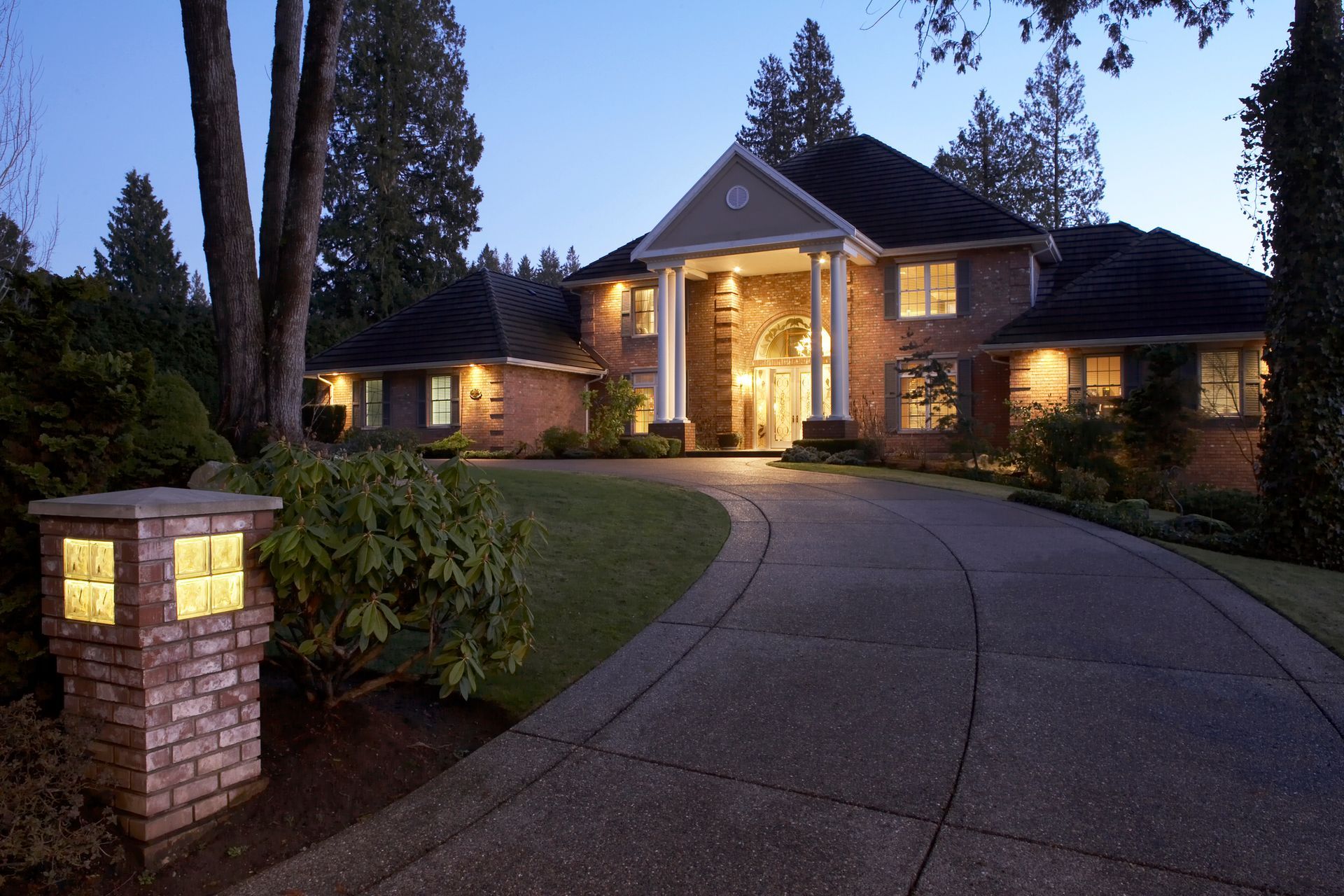 A large brick house is lit up at night.