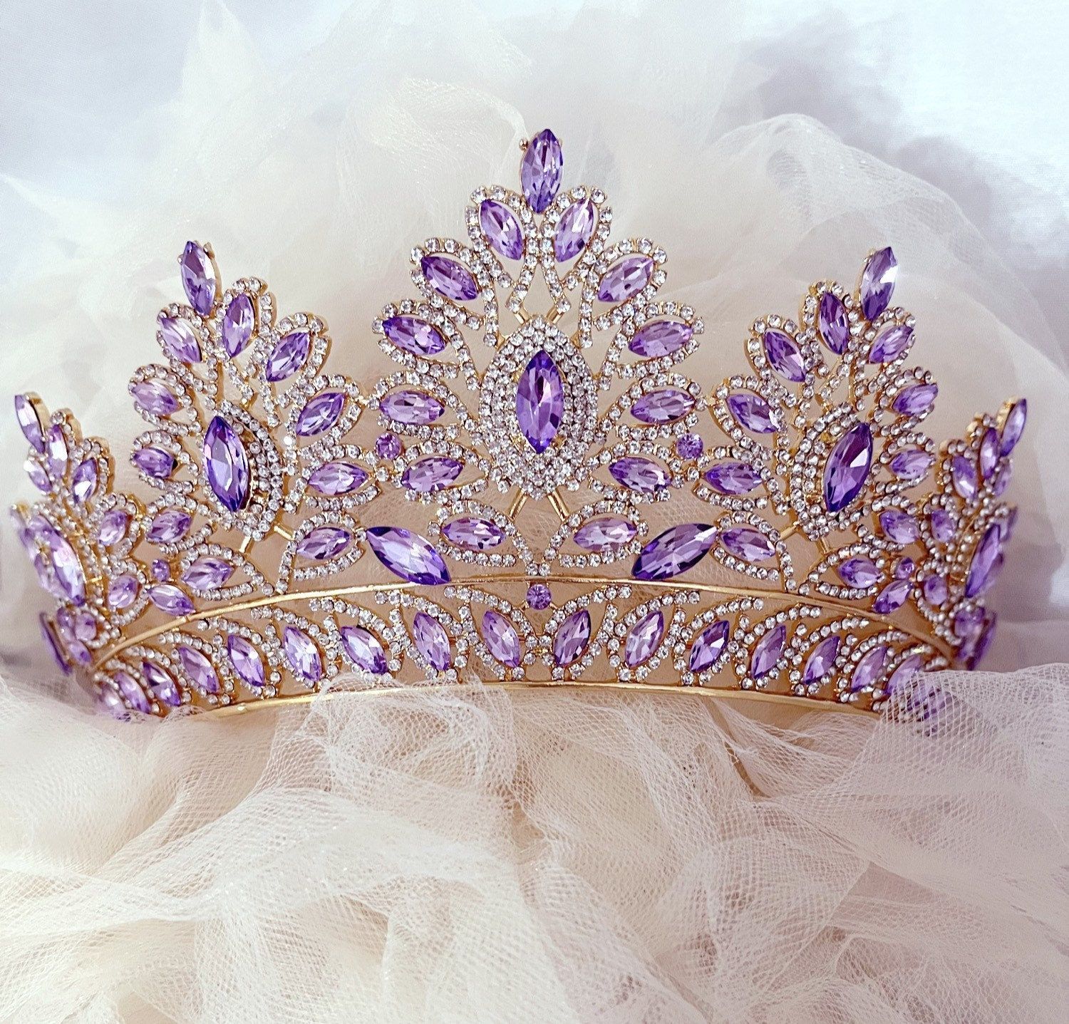 A gold tiara with purple stones and rhinestones