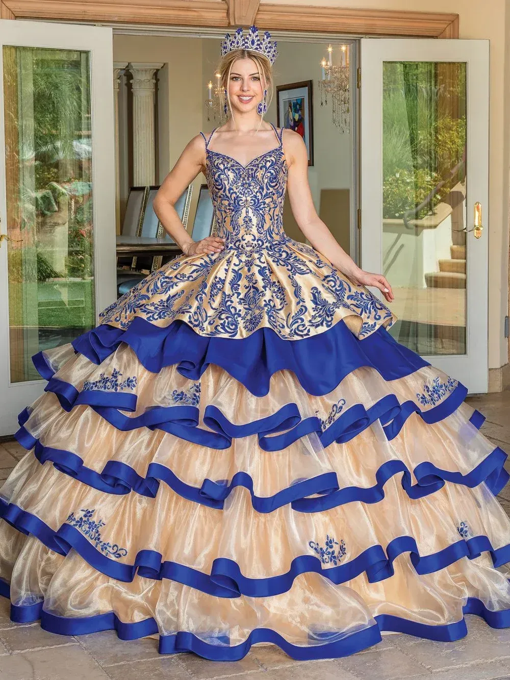 A woman is wearing a blue and gold ball gown.