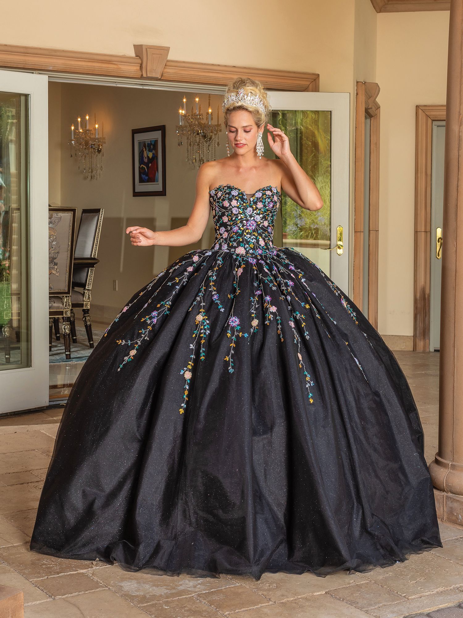 A woman in a black ball gown is standing in a room.