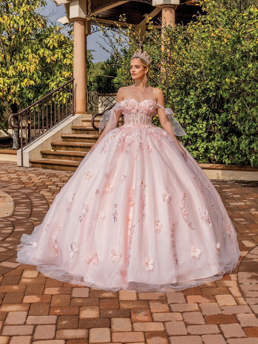 A woman is wearing a pink ball gown and a crown.