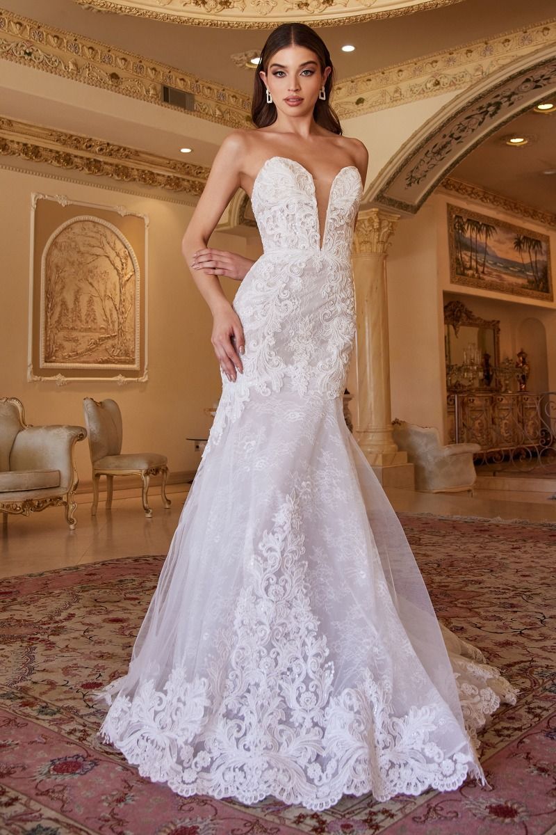 A woman in a white wedding dress is standing in a room.