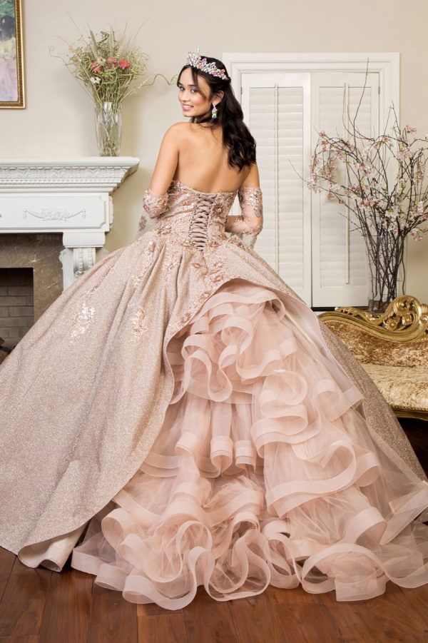 The back of a woman in a ball gown is shown.