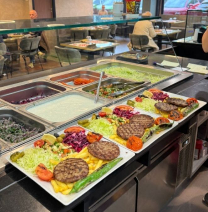 Bar self-service di insalate con un assortimento di condimenti freschi e piatti in una mensa.