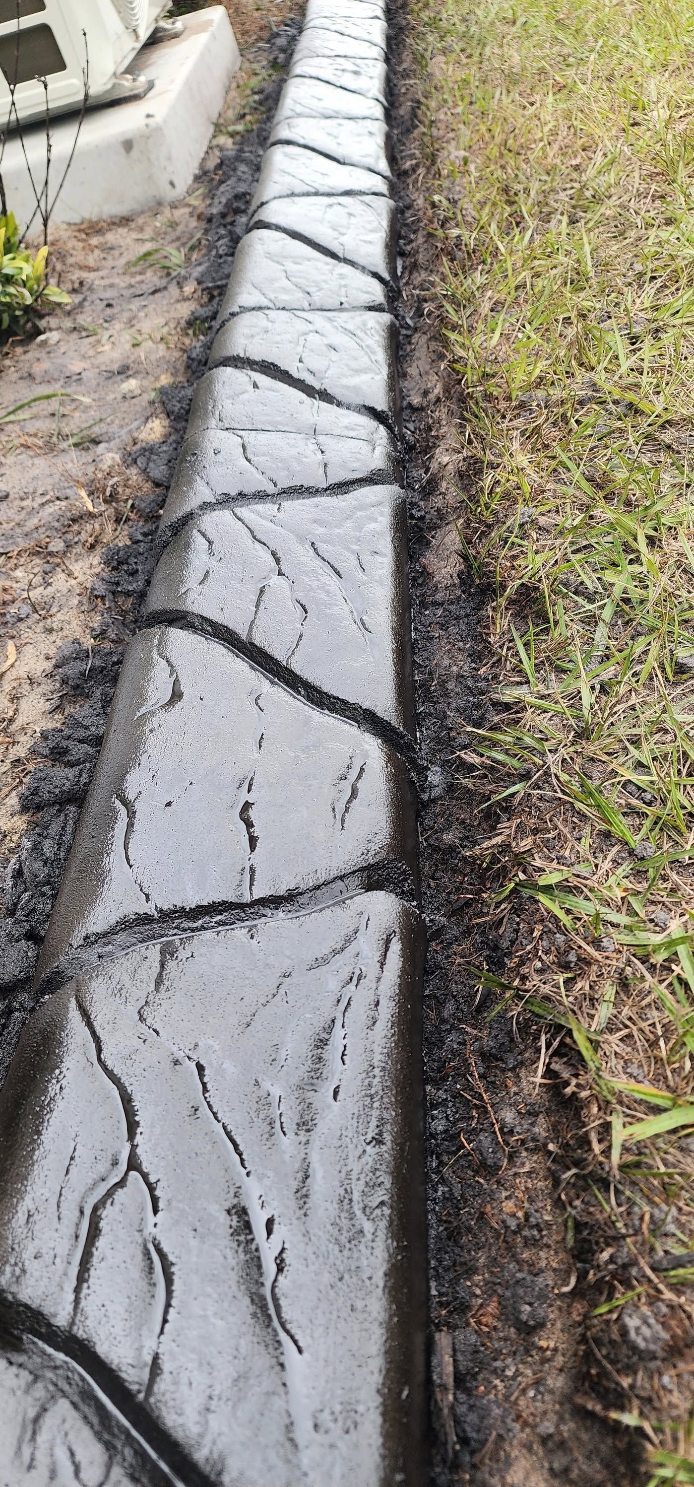 New Era Landscaping crew preparing soil edge for decorative concrete curbing installation at a Polk County FL residential property.
