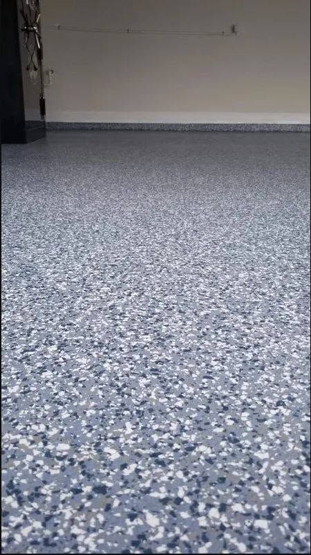 Blue-speckled carpet in an empty room with a plain wall and baseboard.