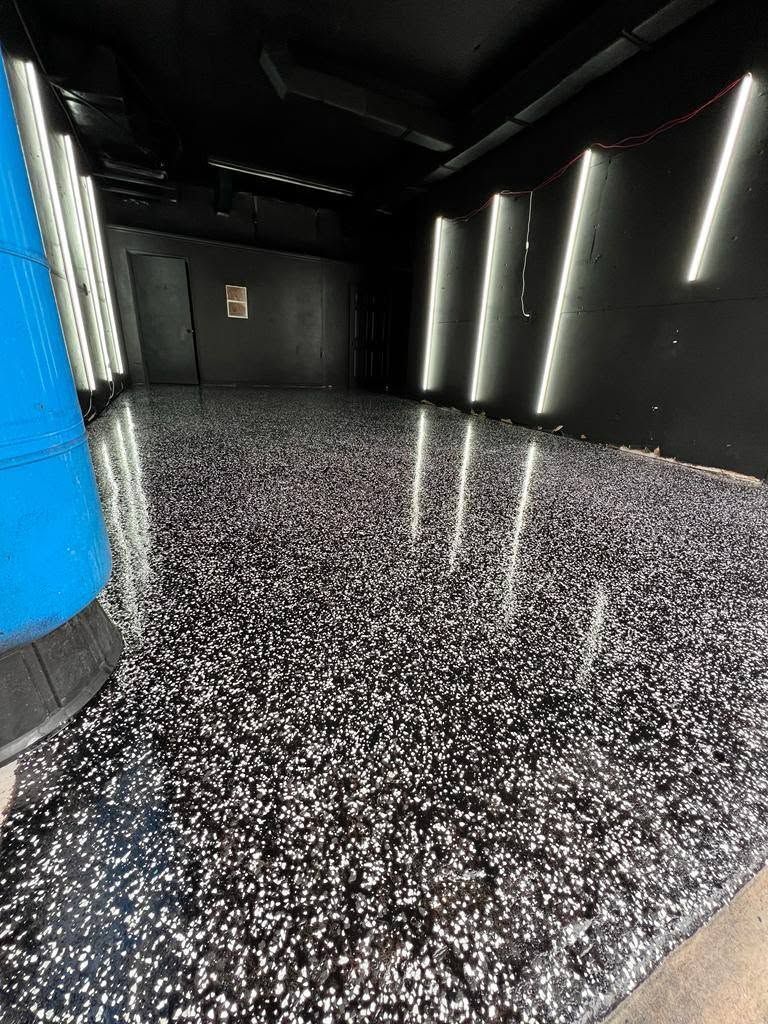New Era Landscaping technician diamond grinding a garage concrete floor before epoxy coating installation in Lakeland FL.
