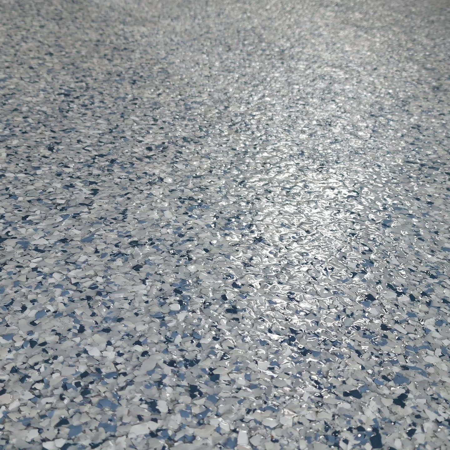 Close-up of a speckled gray and blue textured floor surface