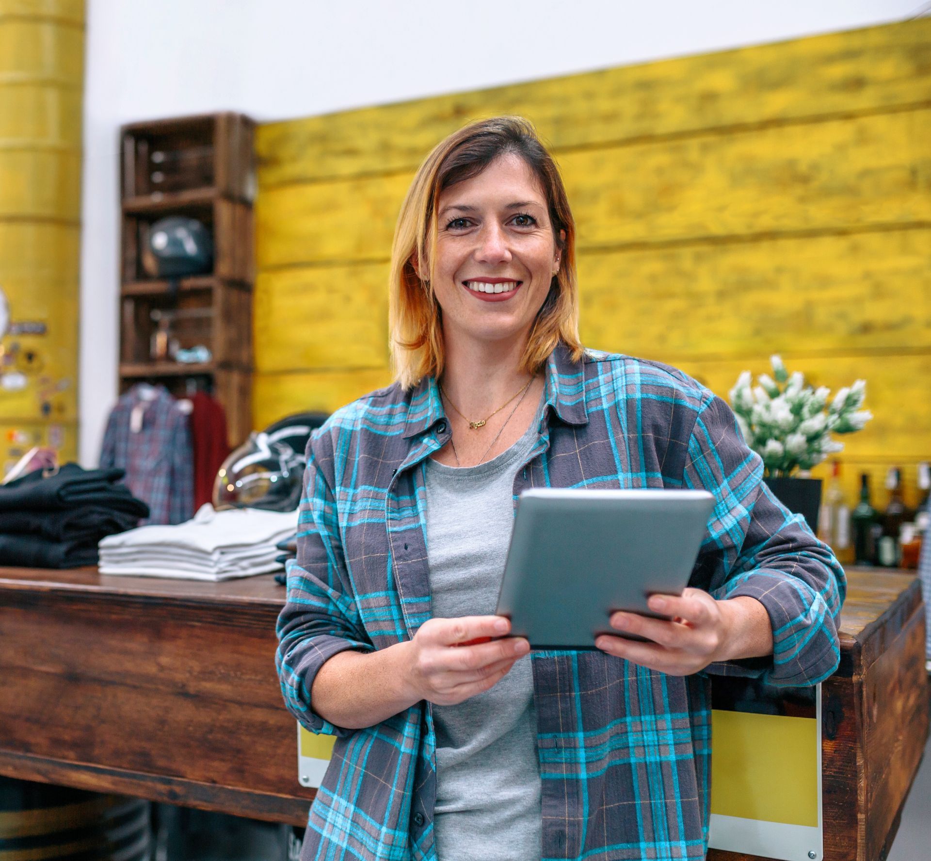 A woman is holding a tablet computer in a store.