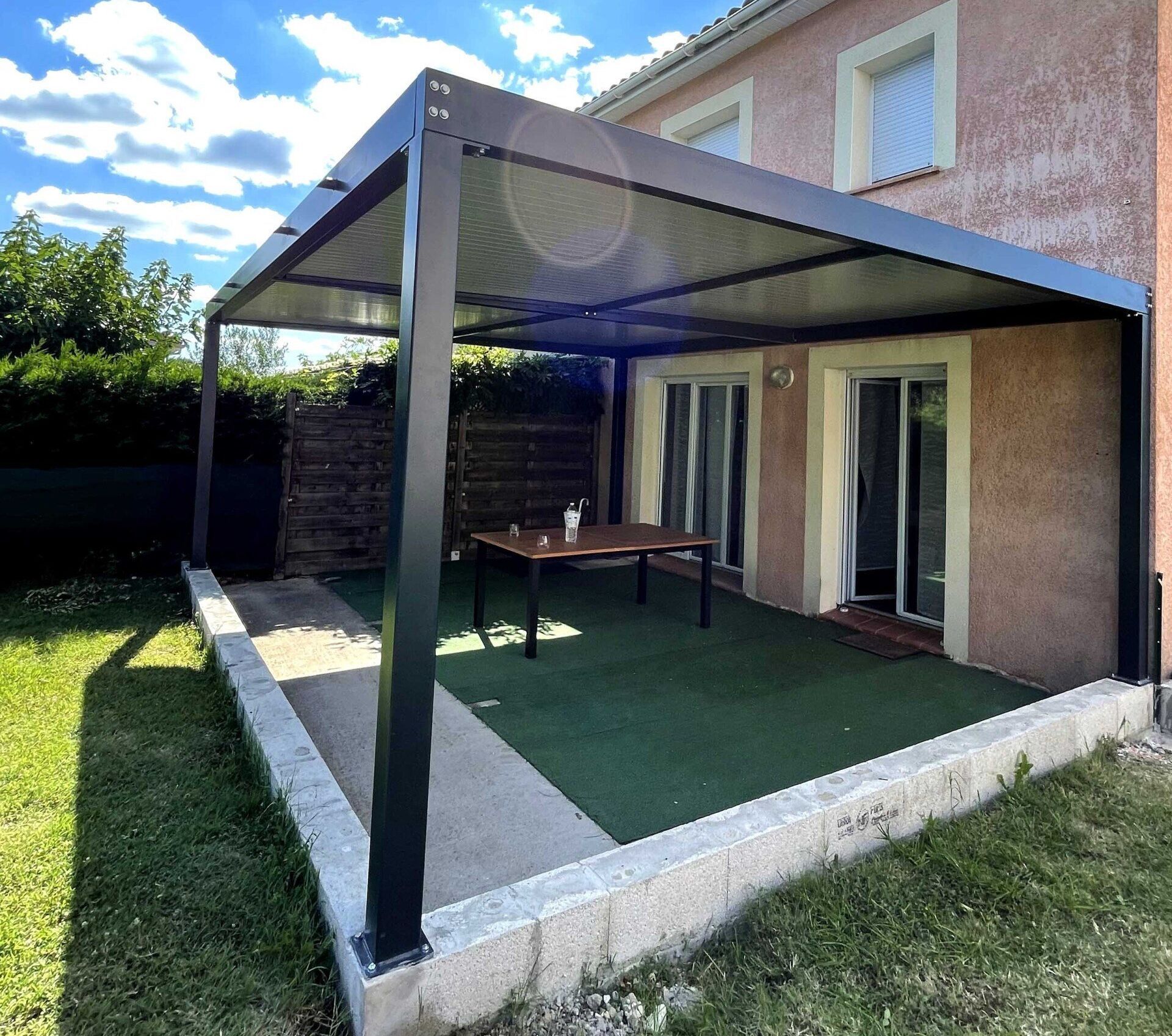 Pergola noire au-dessus d'une terrasse 