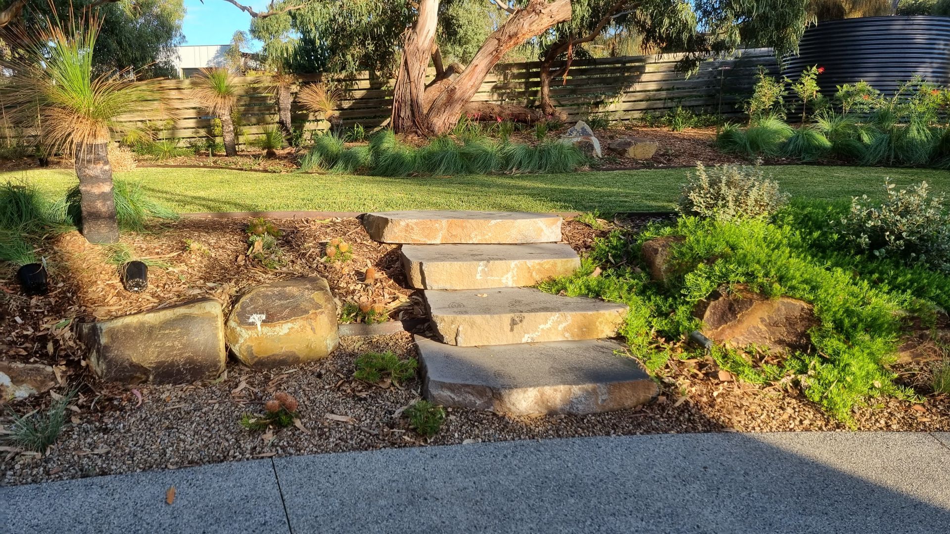 Stone steps leading up a grassy hill in a garden.