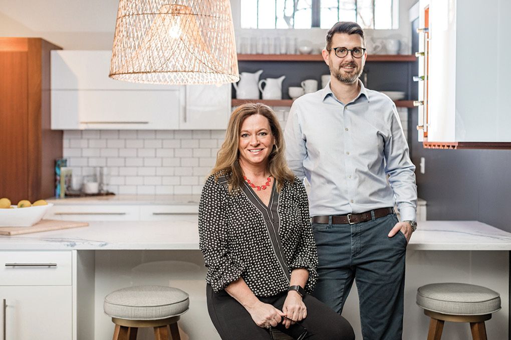 A man and a woman are standing next to each other in a kitchen.