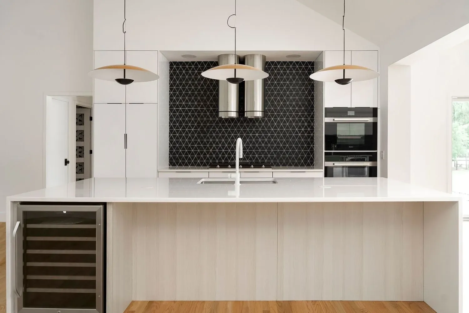 A kitchen with white cabinets and red stools
