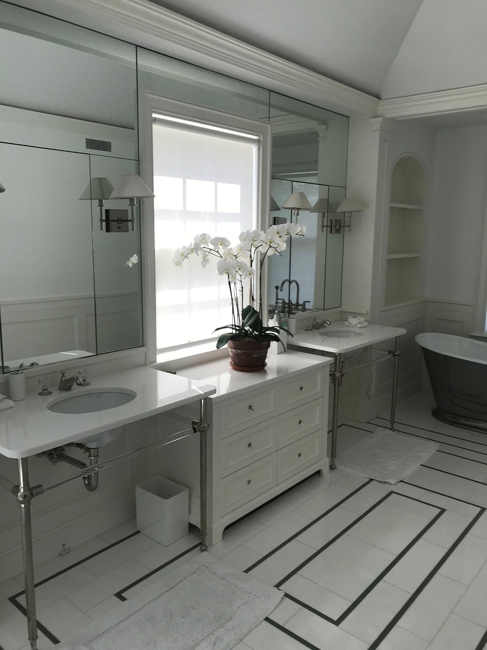 Elegant white bathroom with large mirrors