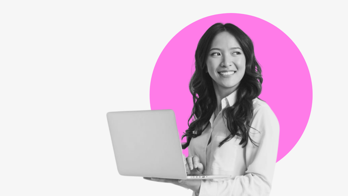 A woman is holding a laptop computer in her hand and smiling.