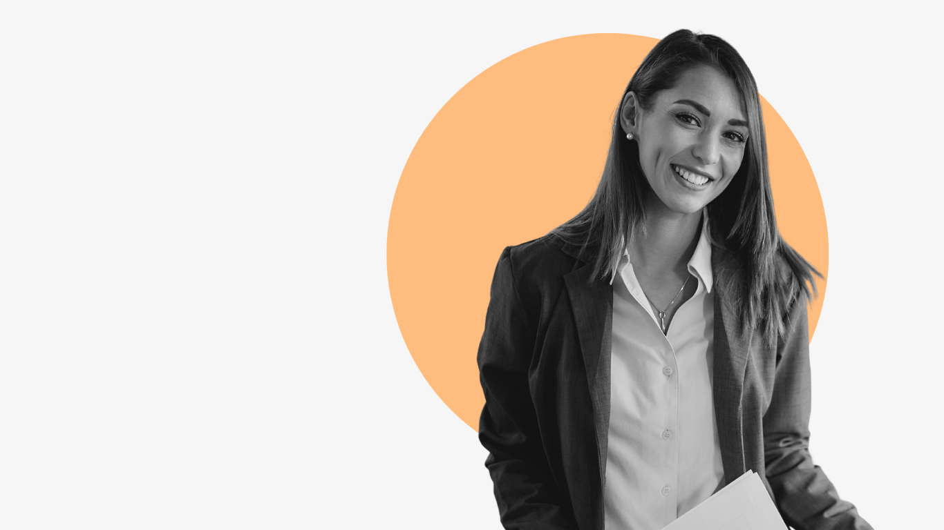 A woman in a suit is holding a piece of paper and smiling.