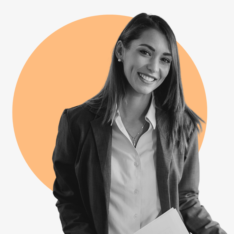 A woman in a suit is smiling and holding a piece of paper.