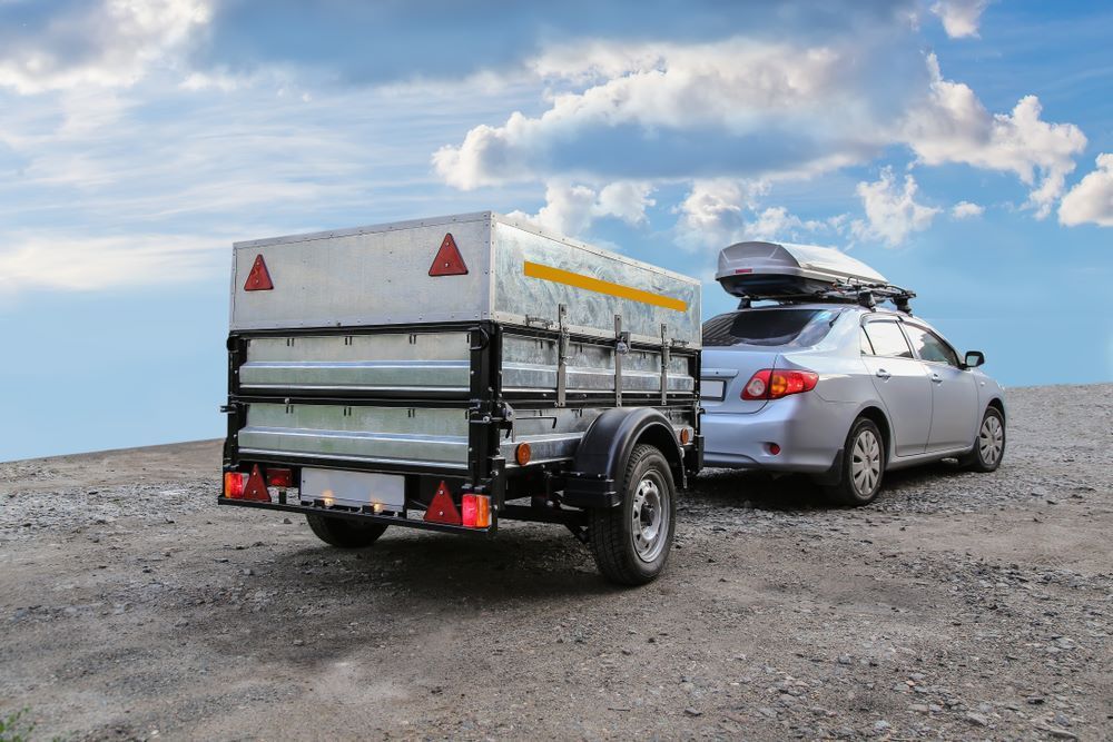 A Car is Towing a Trailer on a Dirt Road — Aura Towing Service in Baringa, QLD