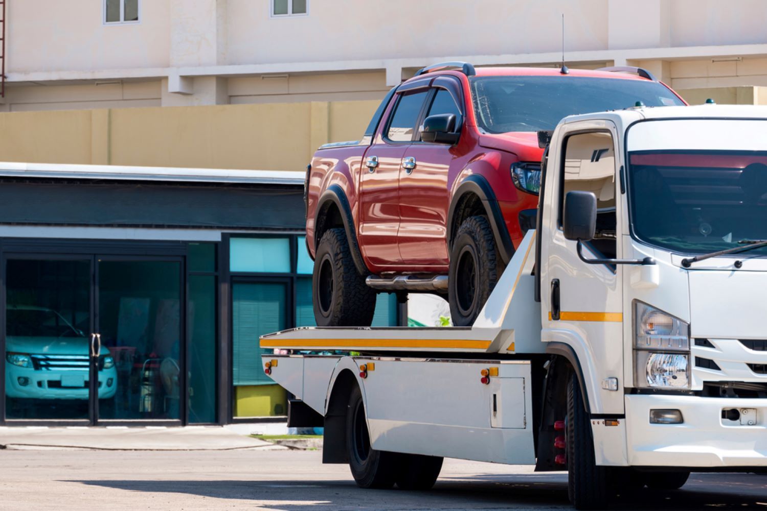 A Red Truck is Being Towed by a Tow Truck — Aura Towing Service in Caloundra, QLD
