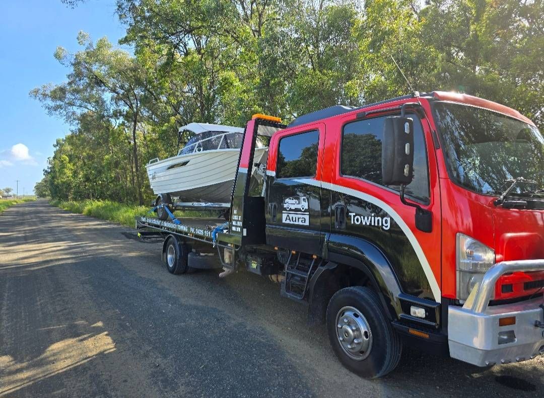 Tow Truck Transporting a White Boat on a Dirt Road — Aura Towing Service in Bells Creek, QLD 
