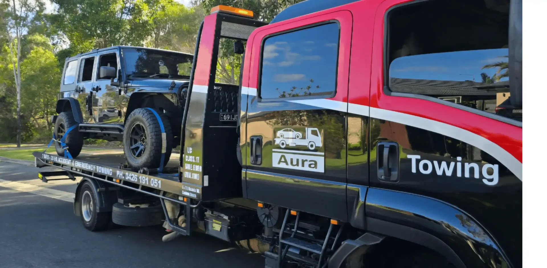 A Tow Truck is Towing a Red Car on the Side of the Road — Aura Towing Service in Baringa, QLD 