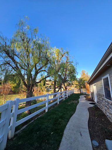 A house with a white fence and a walkway leading to it