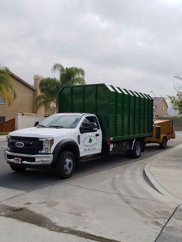 A white truck with a green trailer is parked on the side of the road