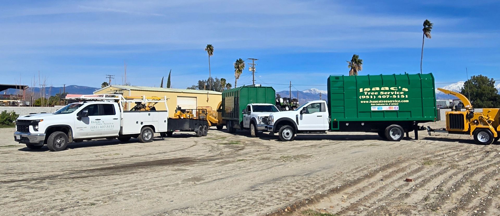 A group of trucks are parked in a dirt field.