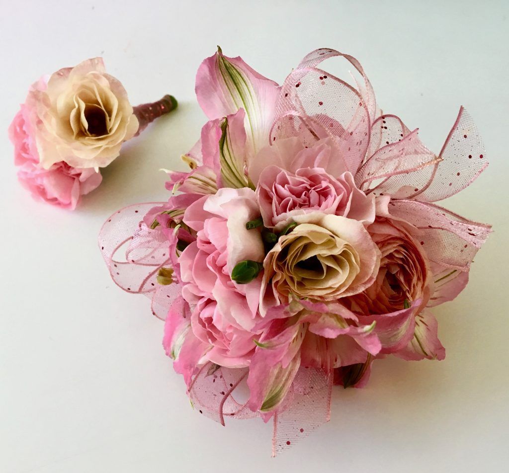 Pink floral bouquet with ribbon and a small matching flower arrangement on a white background
