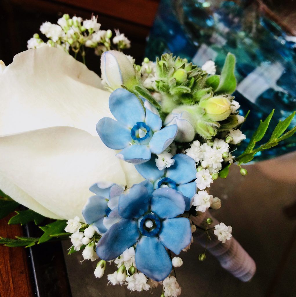 White and blue bridal bouquet with roses, hydrangea, and baby's breath
